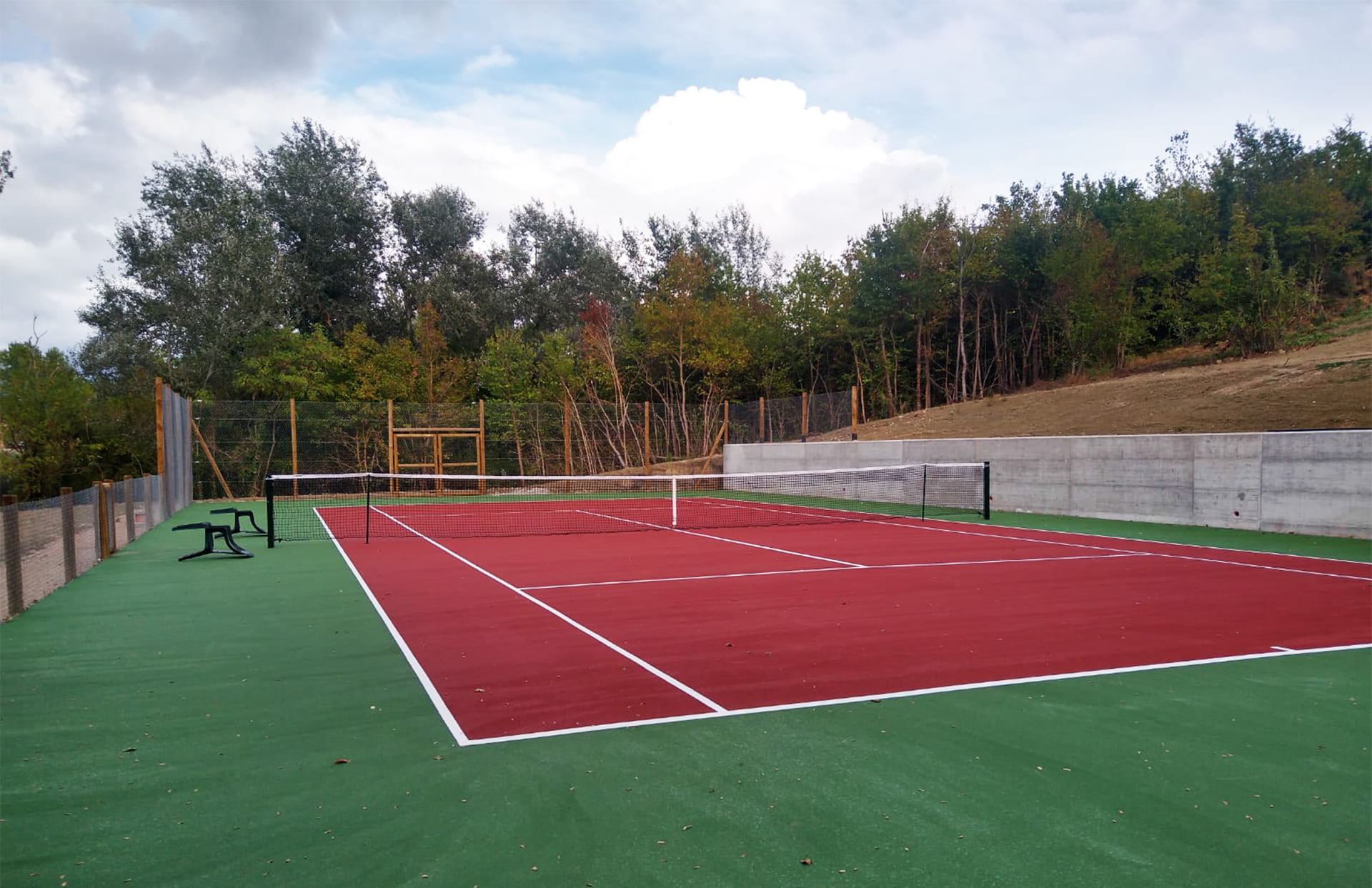 Campo da tennis inserito in un contesto paesaggistico.
